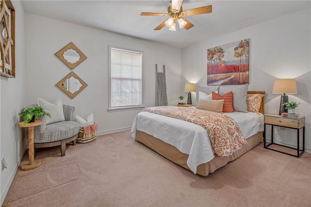 1110 County Road 439 Dime Box, TX 77853 - Photo 33 of 50 a spacious bedroom with a bed and a chandelier