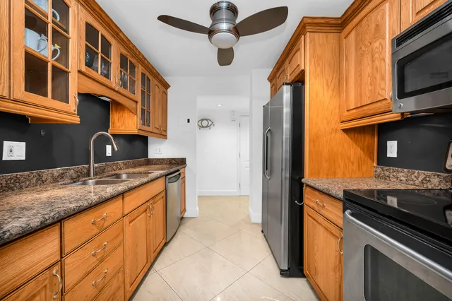 a kitchen with stainless steel appliances granite countertop a sink and a stove