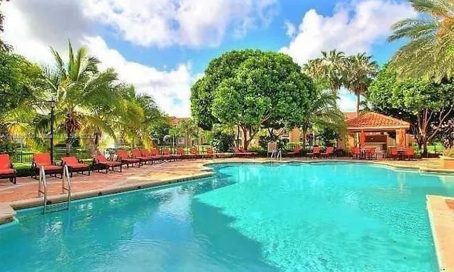 a view of a swimming pool with lawn chairs and a big yard