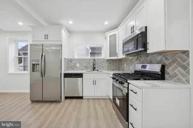 a kitchen with stainless steel appliances granite countertop a stove a sink and a refrigerator