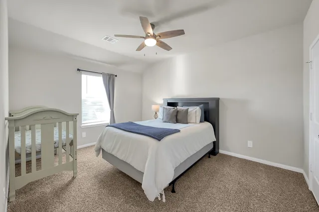 a bedroom with a bed and a ceiling fan
