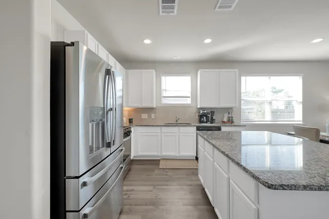a kitchen with stainless steel appliances granite countertop a sink stove and refrigerator