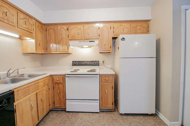 a kitchen with a refrigerator sink stove and cabinets
