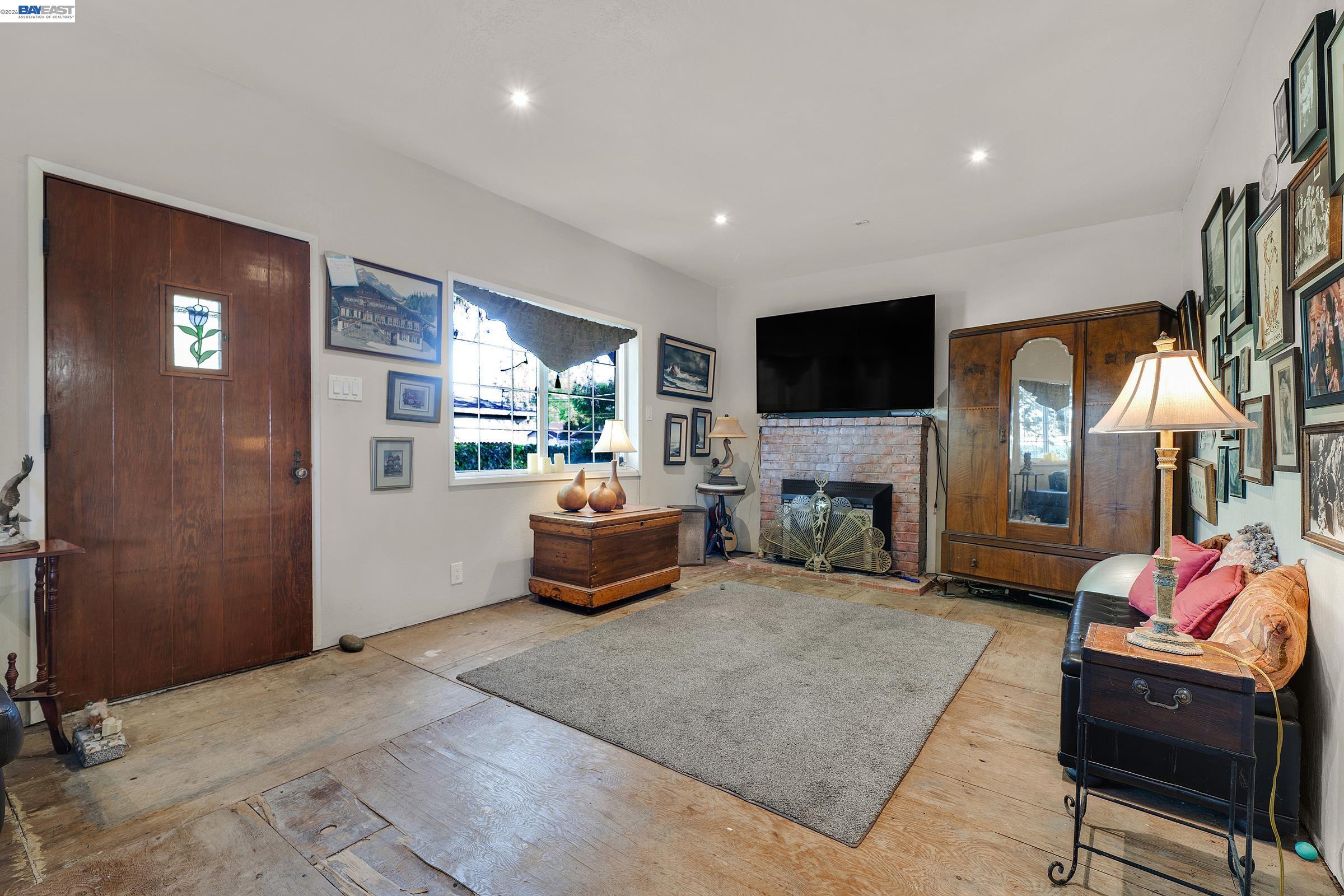 1177 Thiel Road Hayward, CA 94544 - Photo 22 of 55 a living room with furniture a flat screen tv and a fireplace
