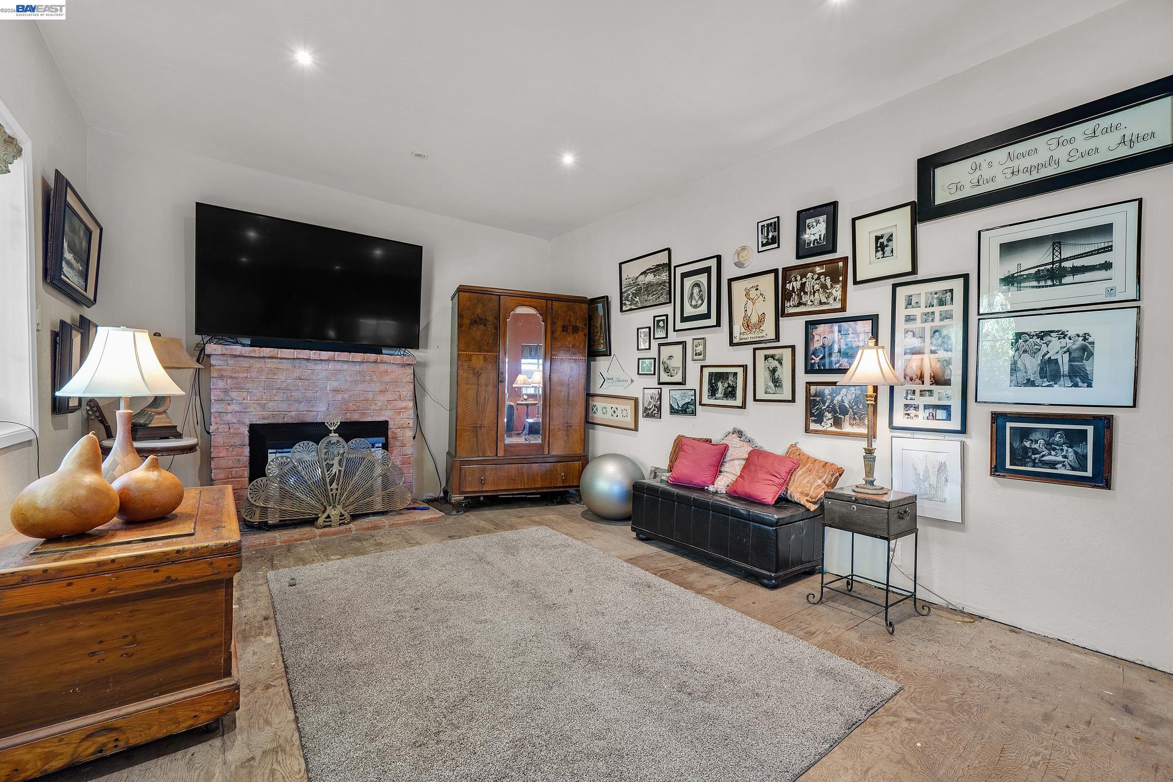 1177 Thiel Road Hayward, CA 94544 - Photo 23 of 55 a living room with furniture a flat screen tv and a fireplace