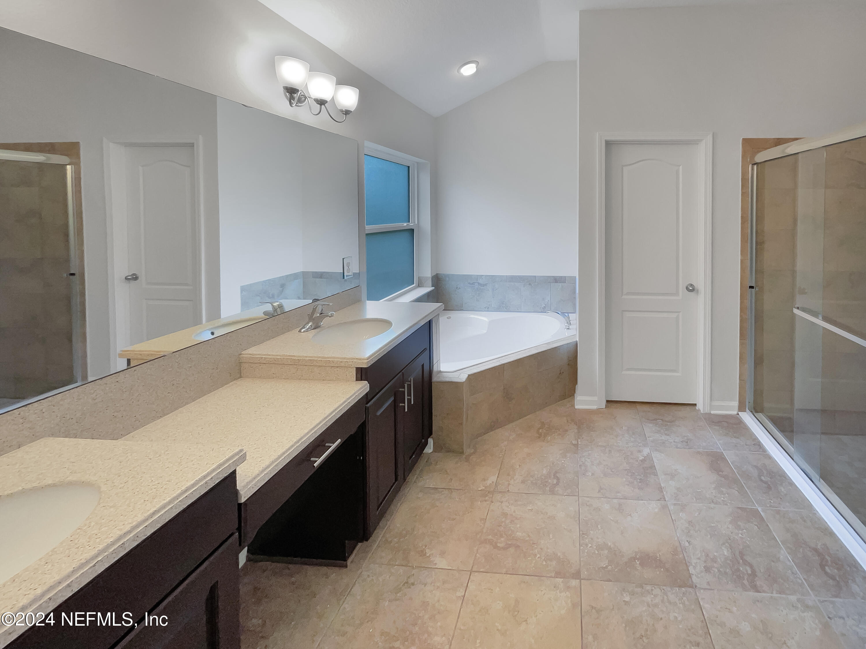 204 Providence Drive St. Augustine, FL 32092 - Photo 15 of 20 a spacious bathroom with a granite countertop sink a bathtub and a large mirror