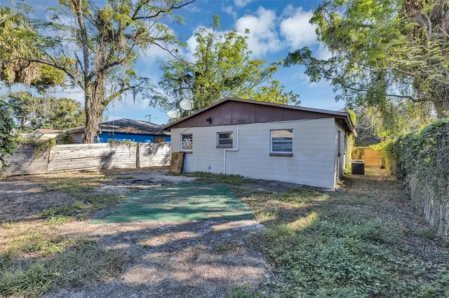 a view of a yard in front of a house with large trees