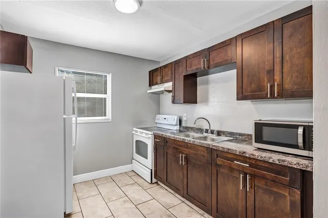 a kitchen with stainless steel appliances granite countertop a sink stove and microwave