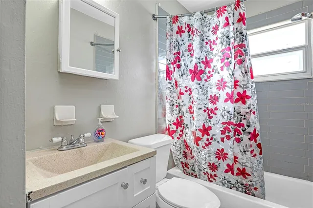 a bathroom with a sink toilet and shower curtain