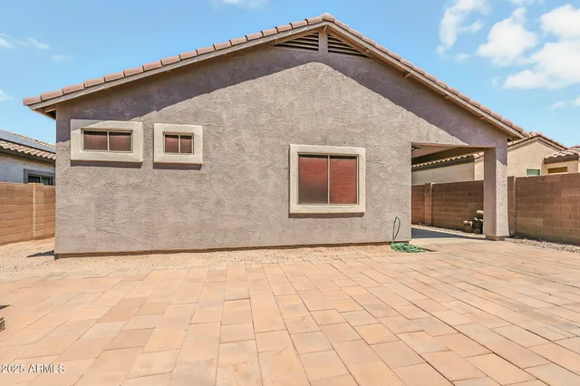 an empty room with chandelier fan and windows