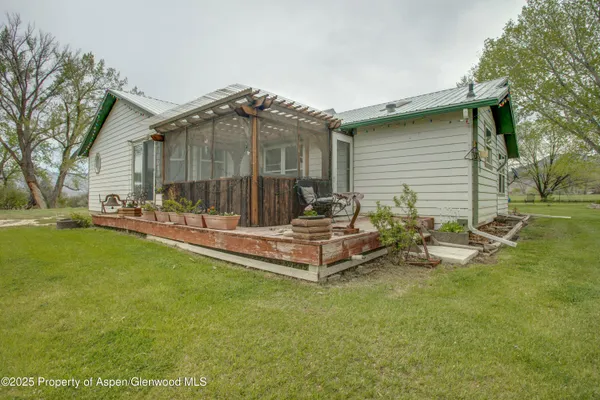 a view of a house with backyard and sitting area