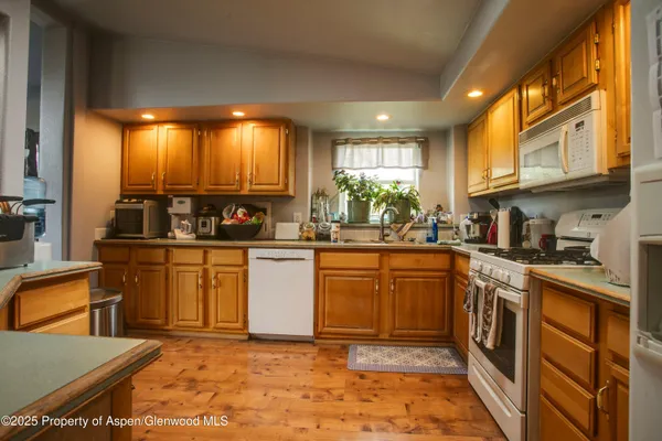 a kitchen with stainless steel appliances granite countertop a stove a sink and a refrigerator