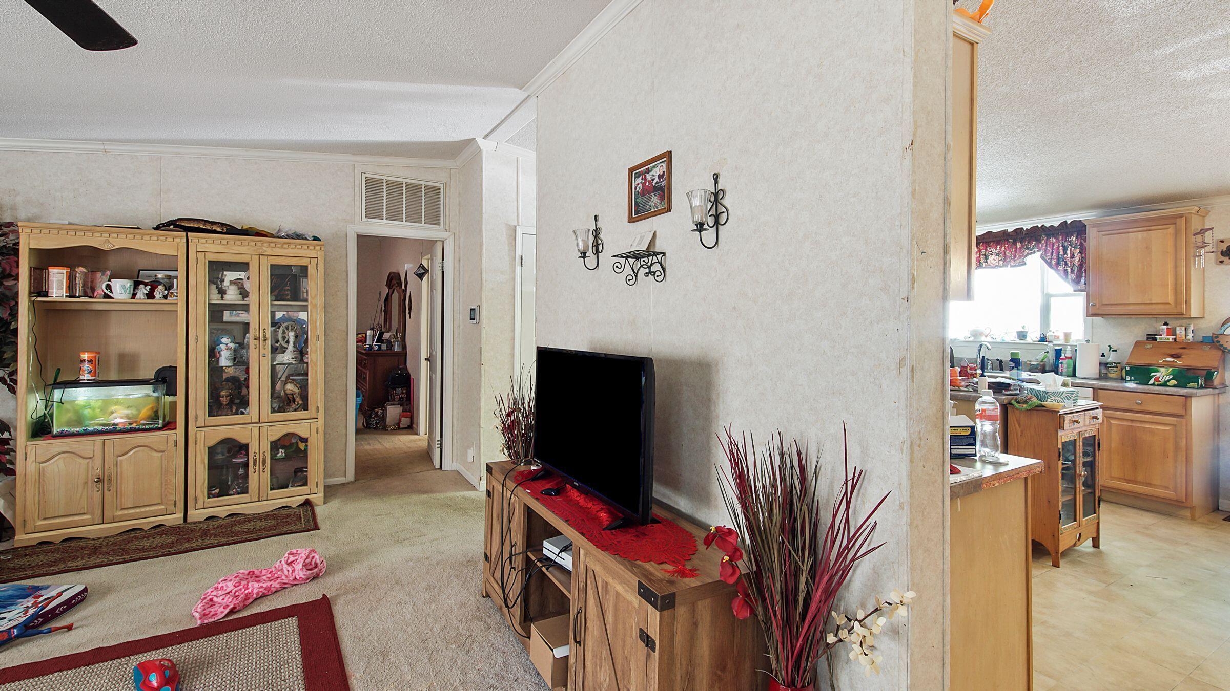127 Madison Street Freeport, FL 32439 - Photo 3 of 8 a living room with furniture a flat screen tv and floor to ceiling window
