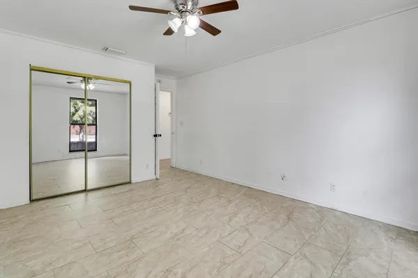 an empty room with fan and windows