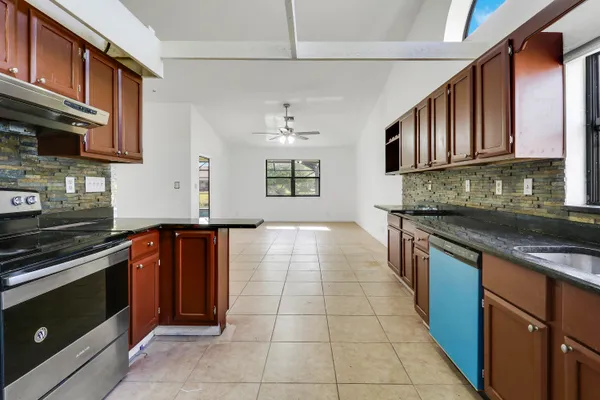 a kitchen with stainless steel appliances granite countertop a stove and a sink