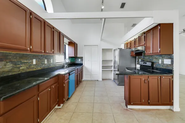 a kitchen with stainless steel appliances granite countertop a stove refrigerator sink and cabinets