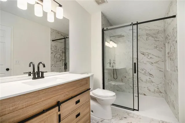 a bathroom with a sink a toilet and shower