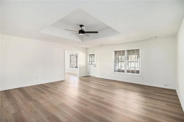 an empty room with wooden floor and windows