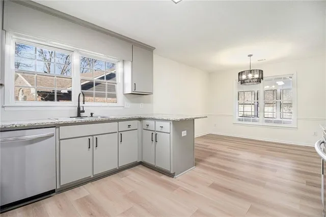a kitchen with granite countertop white cabinets and window