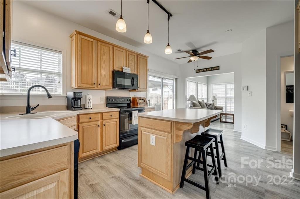 11422 Chapeclane Road Charlotte, NC 28278 - Photo 5 of 19 a kitchen with stainless steel appliances granite countertop a stove a sink a refrigerator a microwave oven with a dining table and chairs