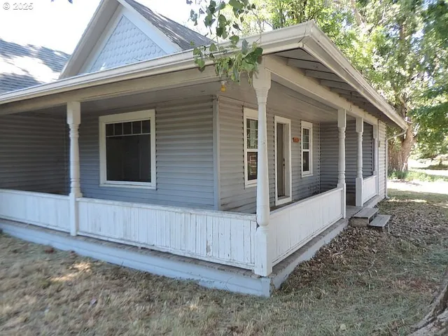 a view of a house with backyard and wooden fence