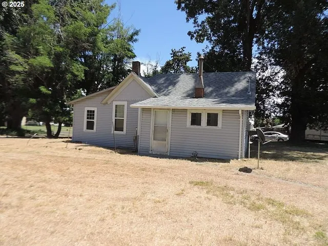 a backyard of a house with a tree