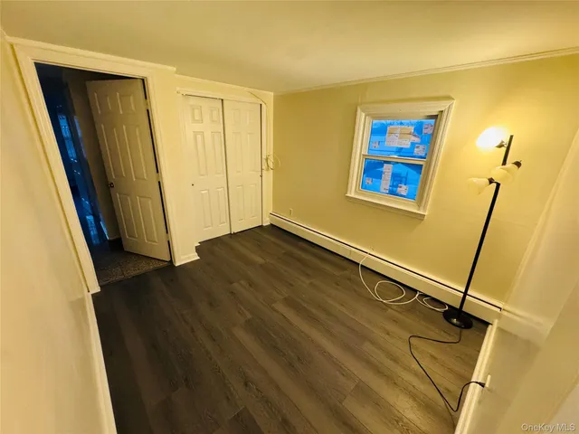 a view of a room with wooden floor and a window