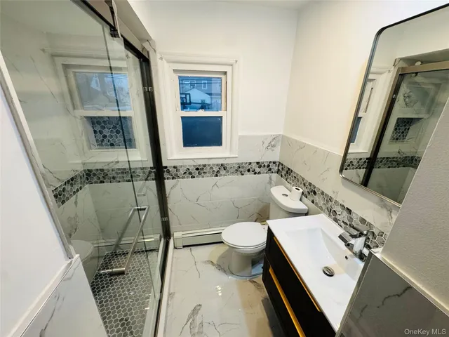 a bathroom with a sink a toilet and shower