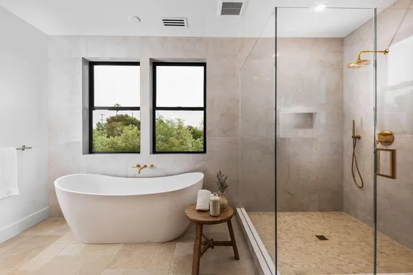 a white bath tub sitting next to a shower