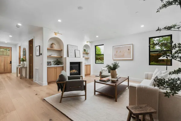 a living room with furniture fireplace and a large window