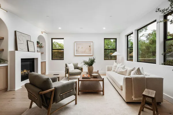a living room with furniture a large window and a fireplace