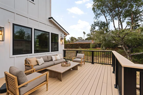 a balcony with wooden floor and iron fence