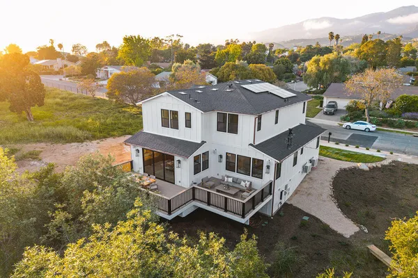 an aerial view of a house with a garden and lake view