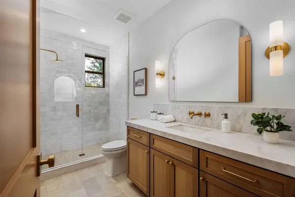 a bathroom with a double vanity sink toilet and shower