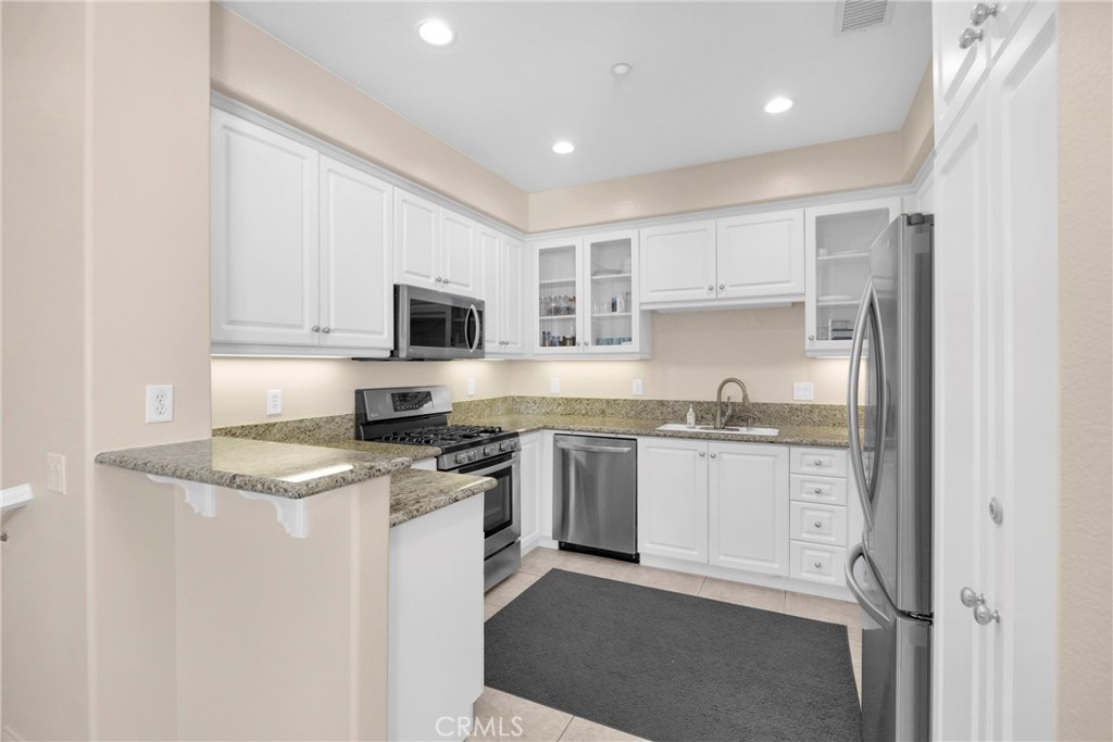 10 Agave Court Ladera Ranch, CA 92694 - Photo 11 of 36 a kitchen with granite countertop stainless steel appliances and white cabinets