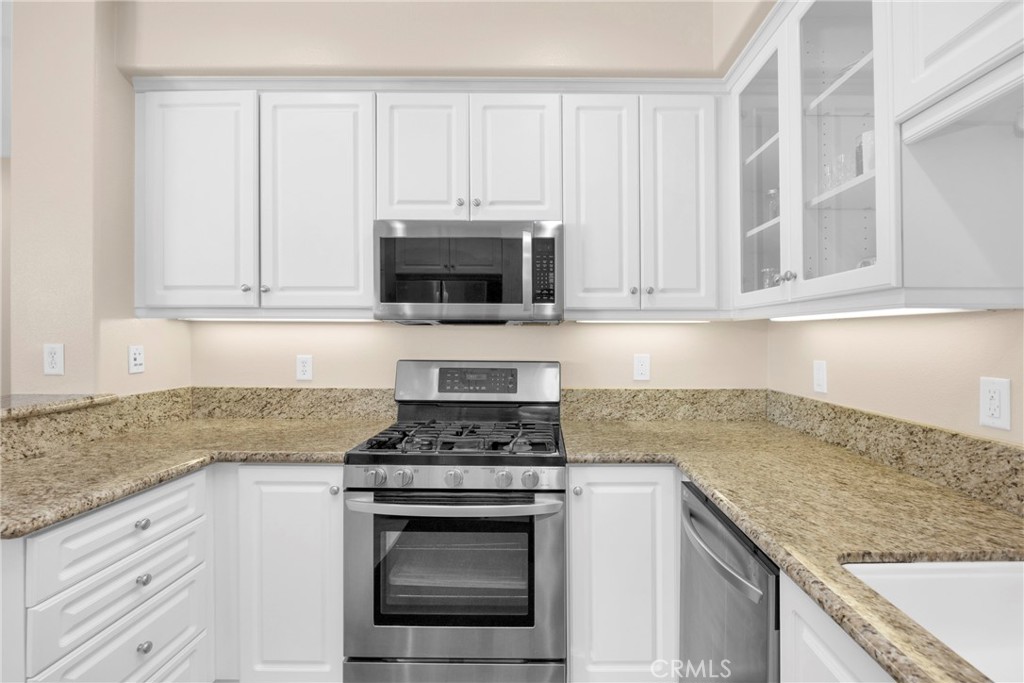 10 Agave Court Ladera Ranch, CA 92694 - Photo 12 of 36 a kitchen with granite countertop white cabinets stainless steel appliances and a sink