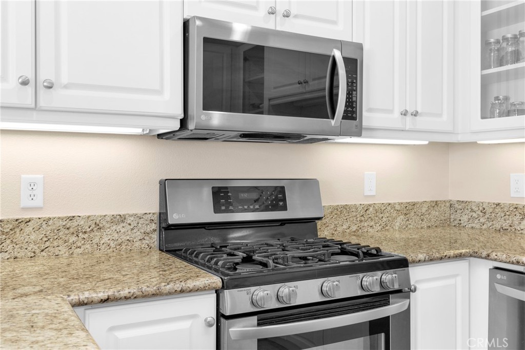 10 Agave Court Ladera Ranch, CA 92694 - Photo 13 of 36 a kitchen with granite countertop a stove and a microwave