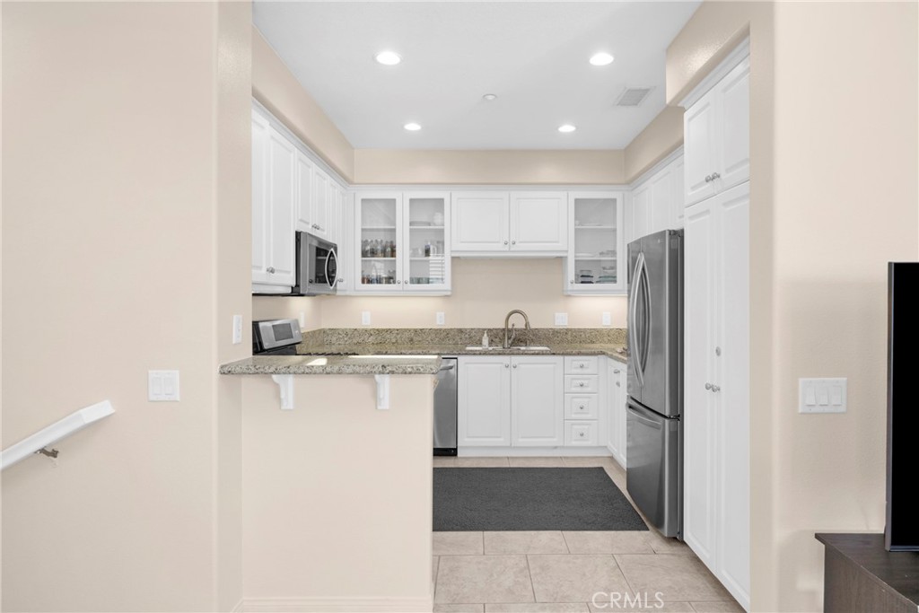 10 Agave Court Ladera Ranch, CA 92694 - Photo 10 of 36 a kitchen with granite countertop white cabinets and refrigerator