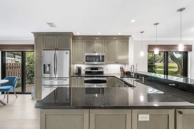a kitchen with a sink a stove and chairs with wooden floor