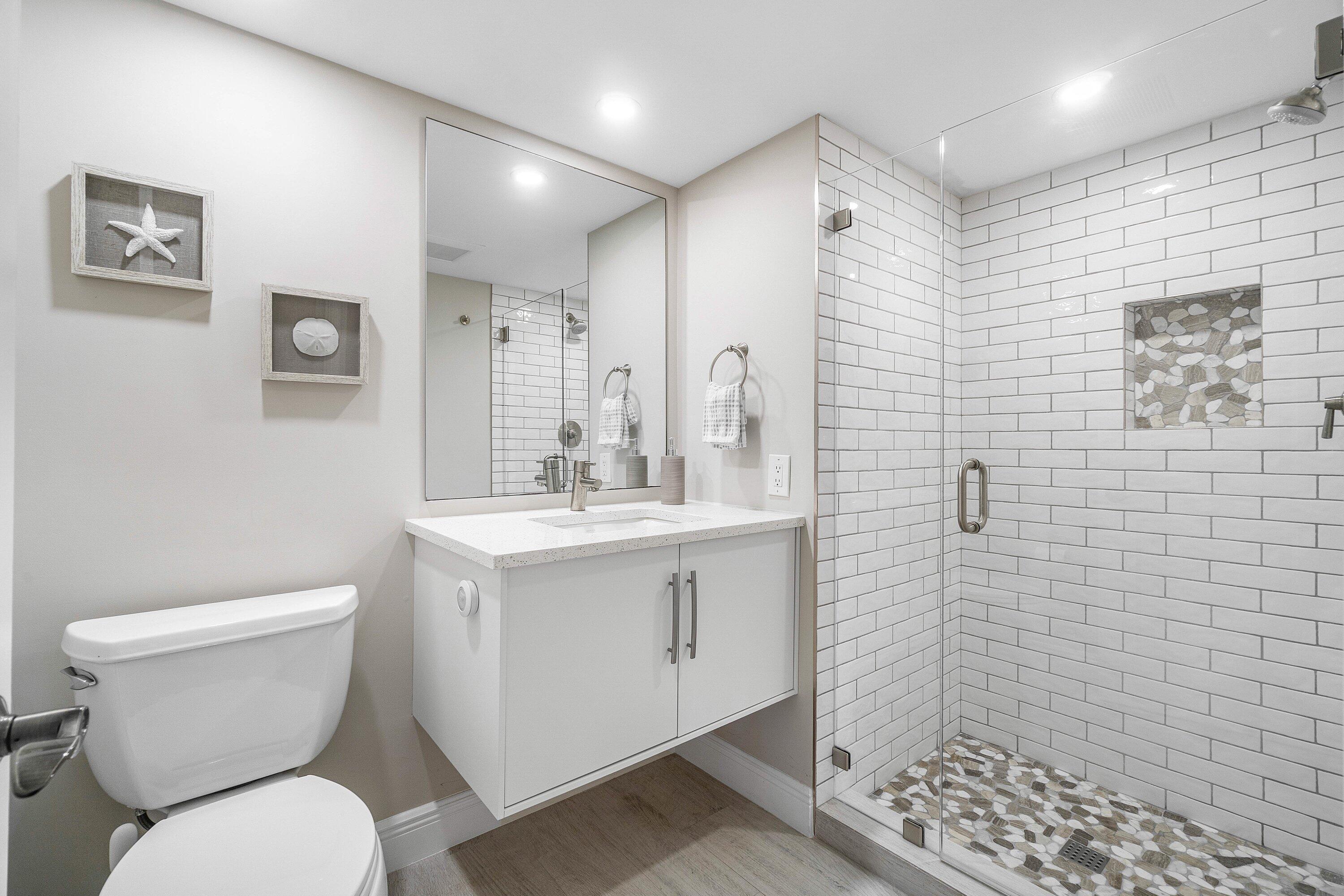 38 Southport Lane, Unit A Boynton Beach, FL 33436 - Photo 13 of 65 a bathroom with a toilet sink and shower