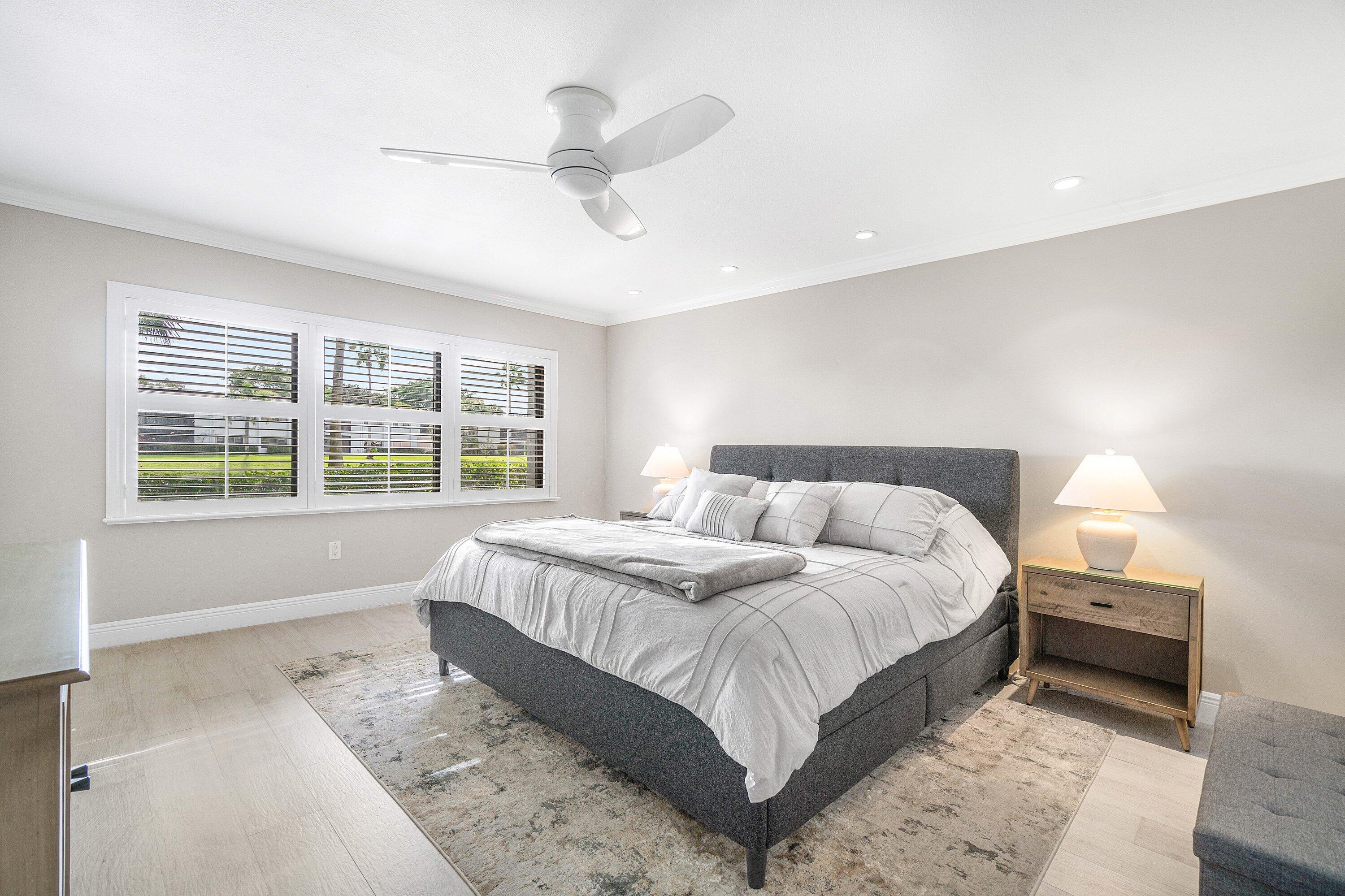 38 Southport Lane, Unit A Boynton Beach, FL 33436 - Photo 16 of 65 a bedroom with a large bed and a large window