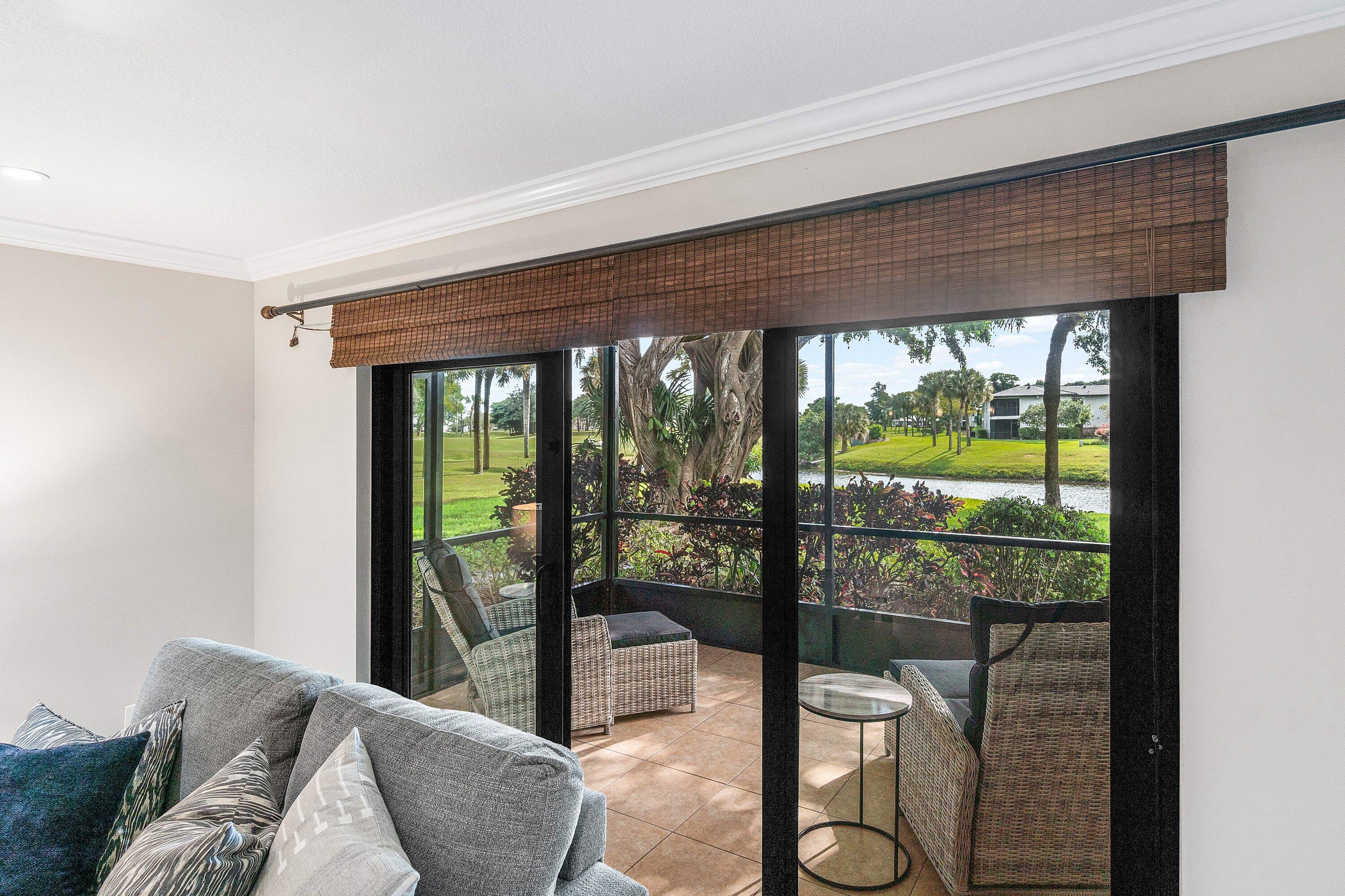 38 Southport Lane, Unit A Boynton Beach, FL 33436 - Photo 8 of 65 a living room with a floor to ceiling window and wooden floor