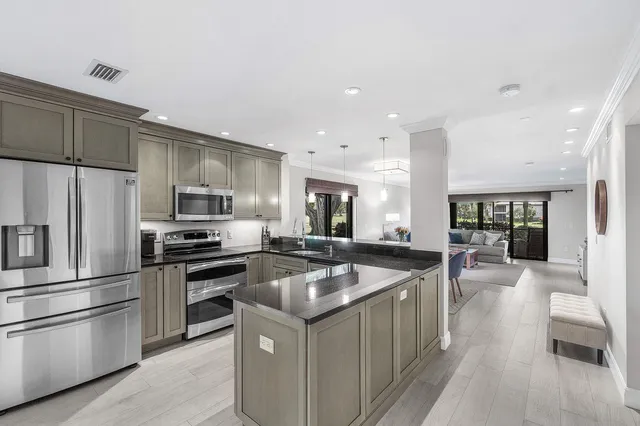 a kitchen with stainless steel appliances granite countertop a sink a stove and a refrigerator