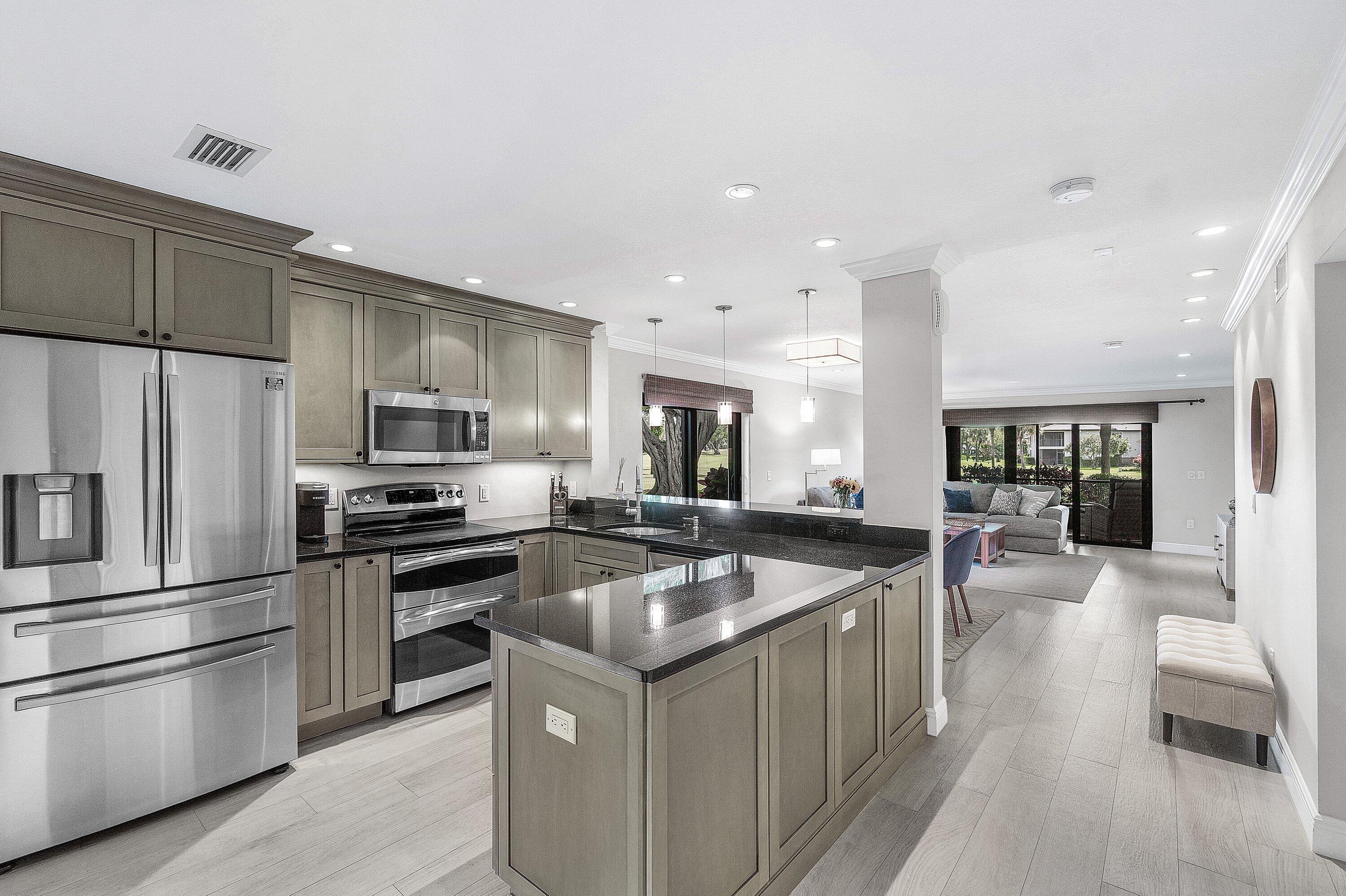 38 Southport Lane, Unit A Boynton Beach, FL 33436 - Photo 9 of 65 a kitchen with stainless steel appliances granite countertop a sink stove and refrigerator