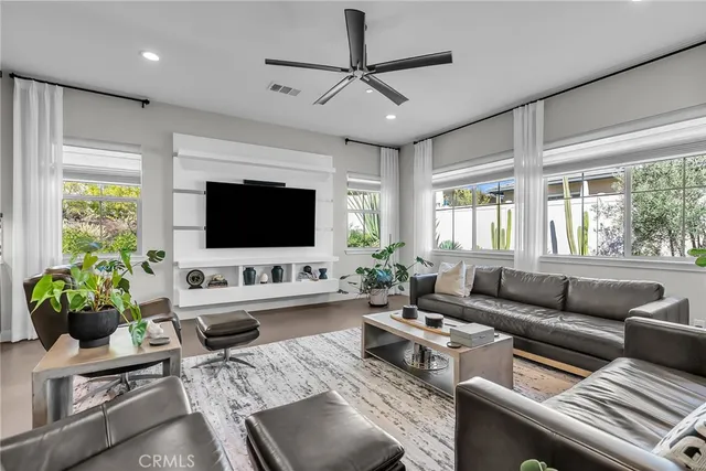 a living room with furniture a flat screen tv and a large window