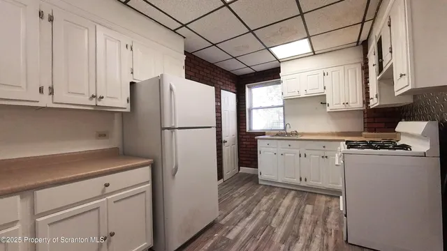 a kitchen with granite countertop a refrigerator sink and stove