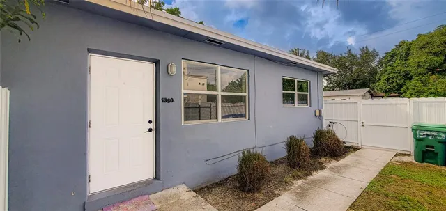 a view of backyard with a table and chairs and potted plants