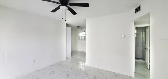 a view of a hallway with a ceiling fan