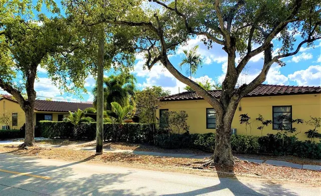 a view of a house with trees in front of it