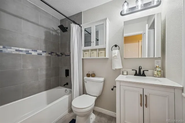 a bathroom with a bathtub toilet sink vanity and mirror